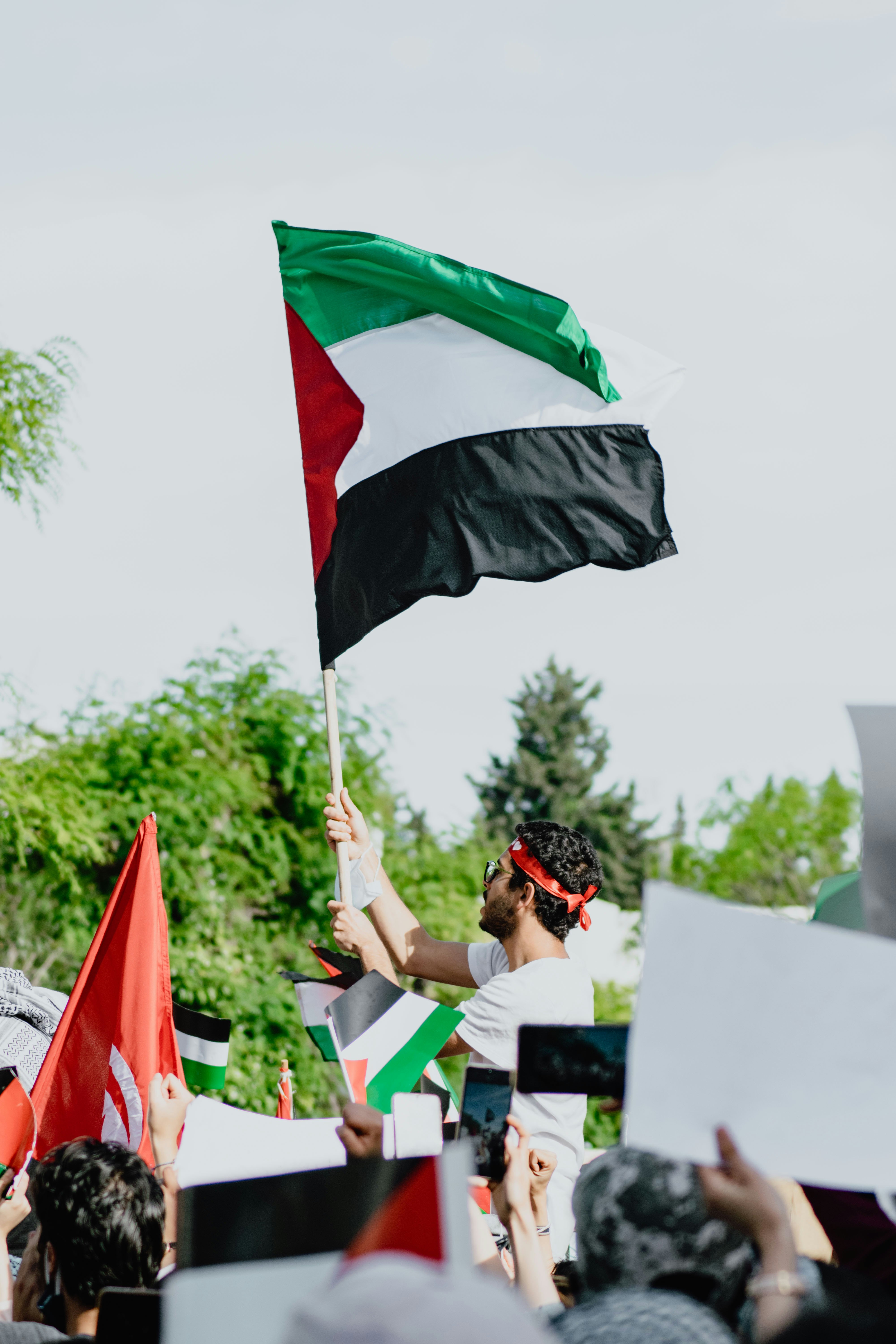 woman in black and white stripe shirt holding green and red flag